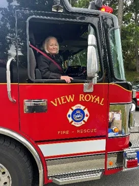 Kathy Leatham waving from the driver's side window of a View Royal Fire Rescue truck