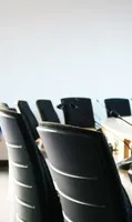 Blurred background of a conference room with several black office chairs