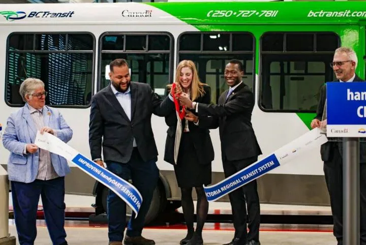 Officials participating in a ribbon-cutting ceremony for a new transit service