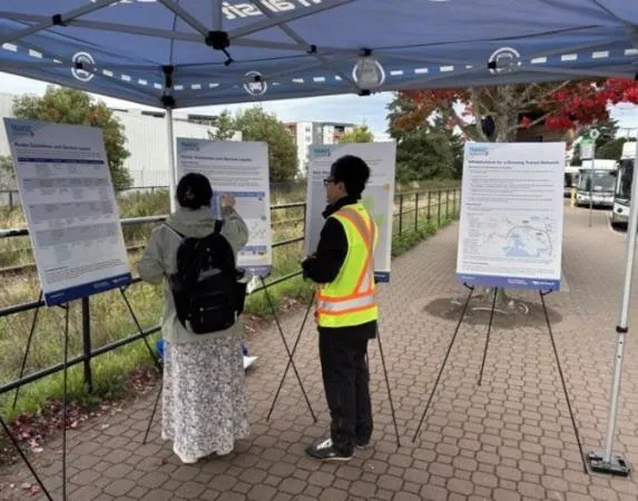 People reviewing information boards at an outdoor public engagement session