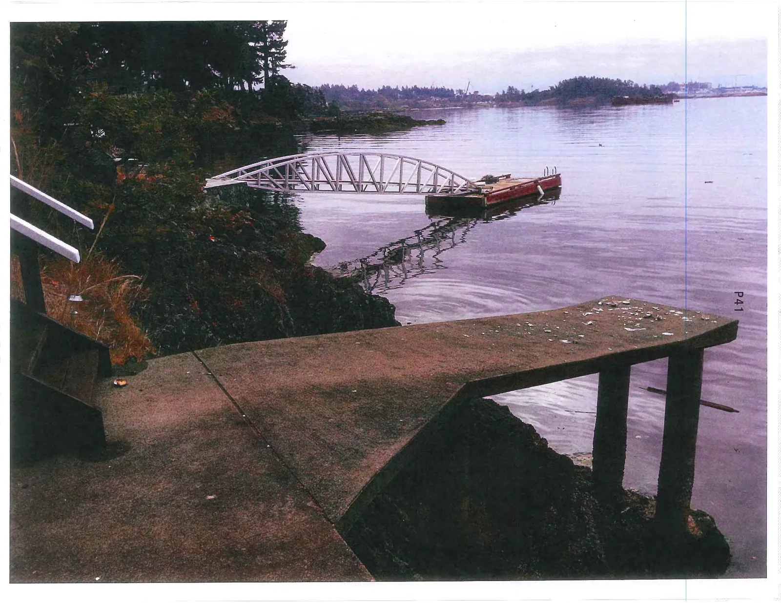 View from the concrete patio showing a platform and a gangway leading to a floating dock.