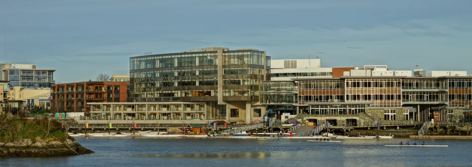 Daytime view of the Selkirk Waterfront Community buildings and rowing docks along the water.