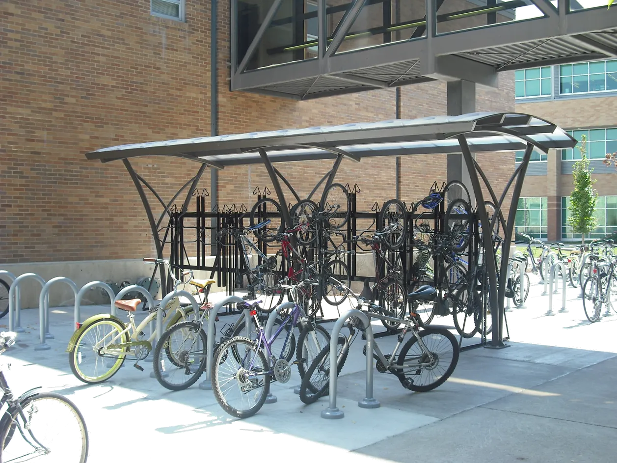 Green "Urban Racks" bicycle maintenance station with integrated tools and an adjacent floor pump