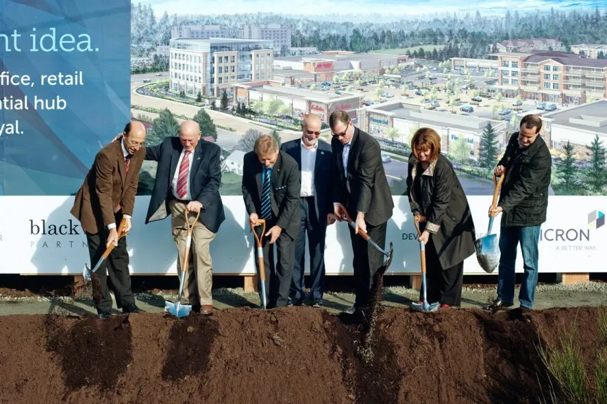 A large billboard for Eagle Creek Village with architectural renderings and project information.