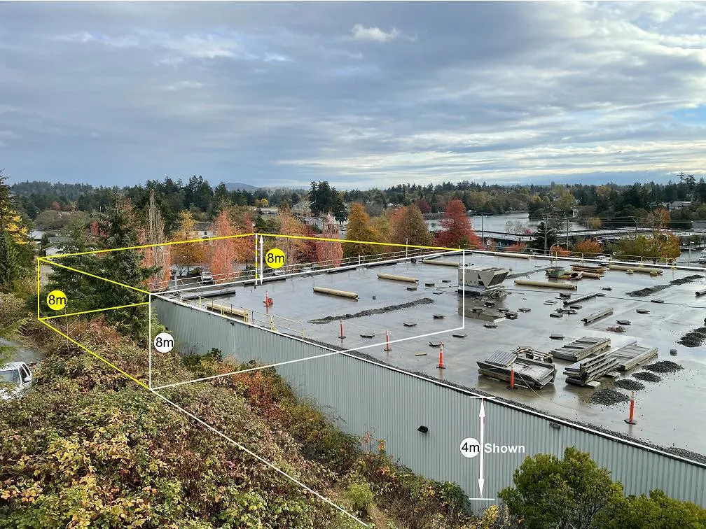 Photo depiction from a top floor home office window showing the proposed building expansion outlined in yellow with height markers of 8m and 4m over an existing large rooftop.