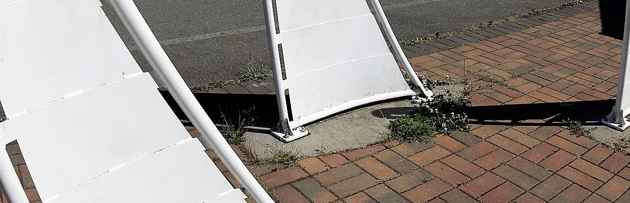 Base of a white decorative structure bolted to a concrete surface