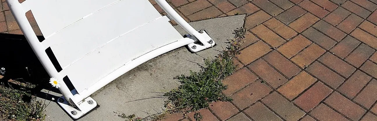 Base of a white decorative structure on a brick-paved area