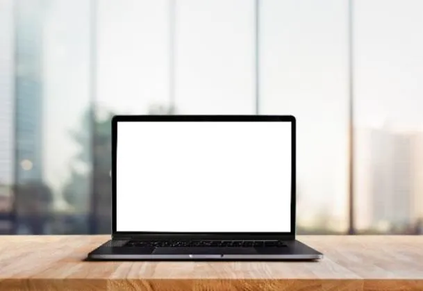 Photo of a laptop on a wooden surface, representing the online survey platform.