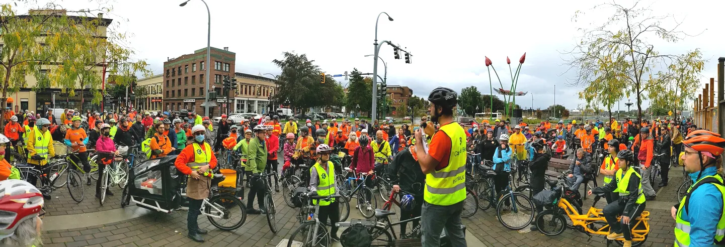 Large crowd of cyclists gathered for an event at an intersection