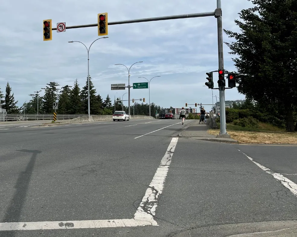 Photo of a street corner with a public bench and planter