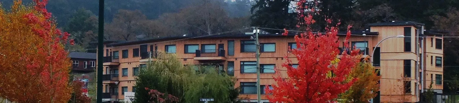 Apartment building with red autumn trees in the foreground