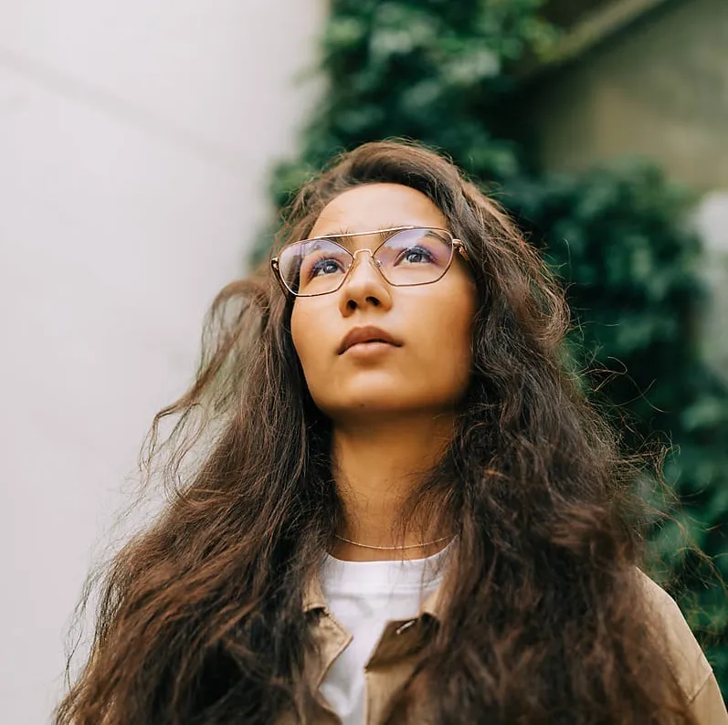 A woman with glasses looking upwards