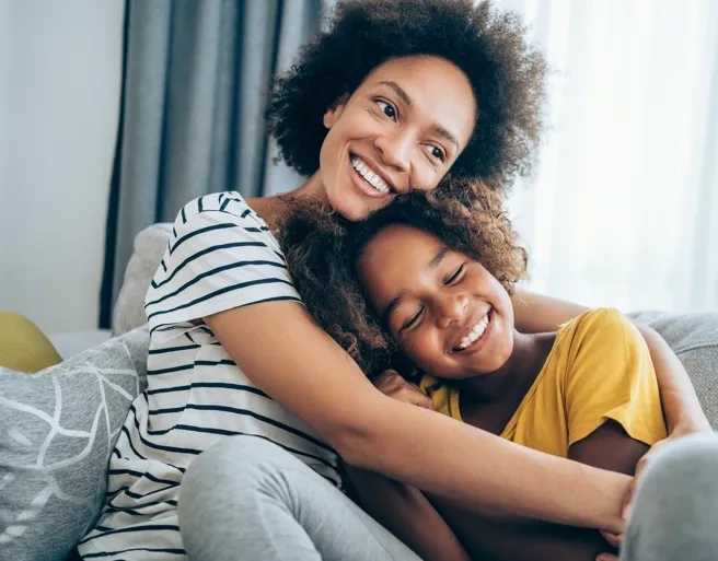 A man and woman smiling while looking at a smartphone