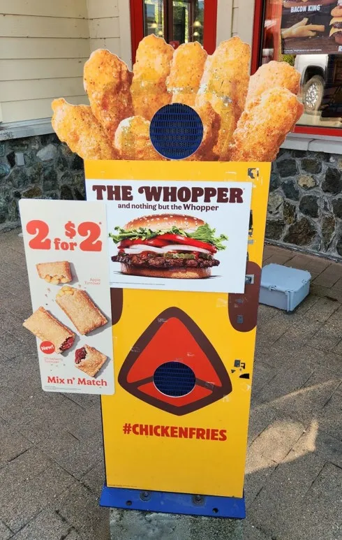 Photograph of an existing promotional drive-thru sign for "Chicken Fries"