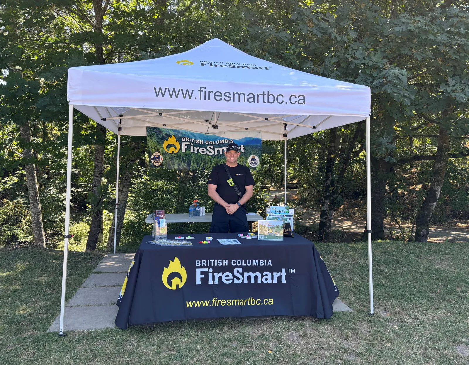 FireSmart information booth at an outdoor event with a representative and informational materials