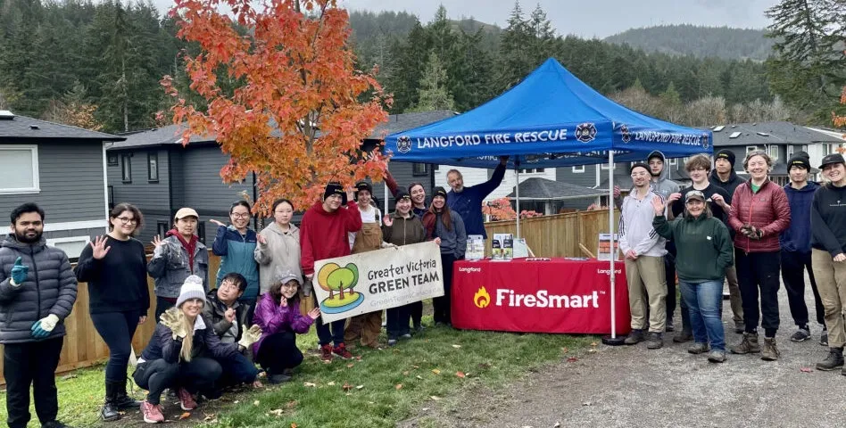 Volunteers from the Greater Victoria Green Team posing with a FireSmart banner at a community event