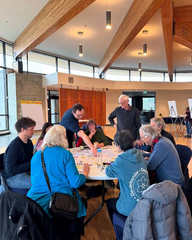 Photo showing community members seated around a table, actively participating in a mapping exercise during a workshop.