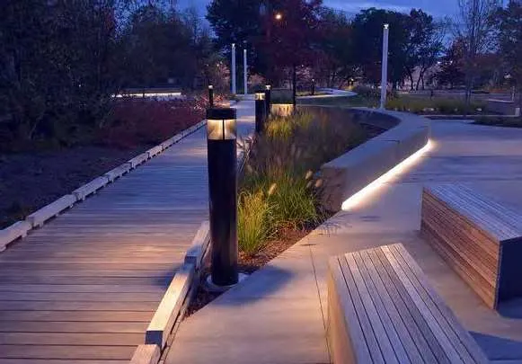 Representative photo of light bollards, illuminated pathway, and integrated bench seating in a landscape setting.
