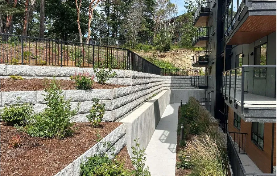 Photo of tiered retaining walls on-site near a multi-story building