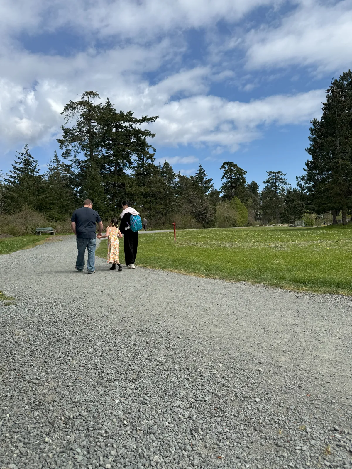 A family walking in View Royal Park on a gravel path