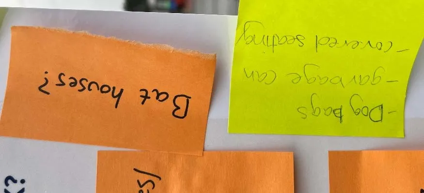 Close-up of sticky notes mentioning bat houses, dog bags, garbage cans, and covered seating