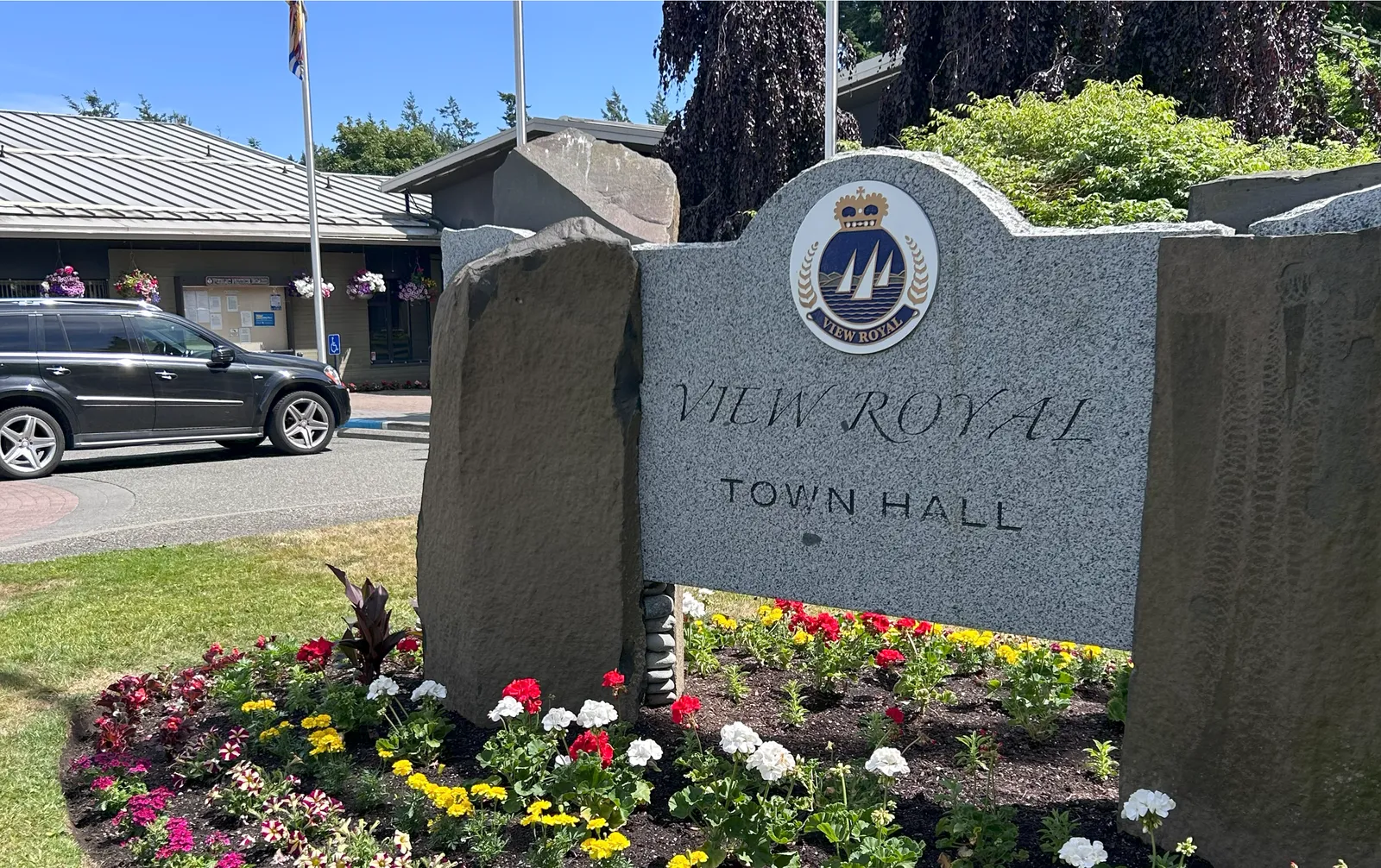 View Royal Town Hall stone sign with a colorful flower bed in front