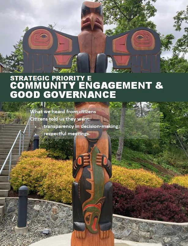 A tall, colorful Indigenous totem pole standing outdoors amidst lush greenery