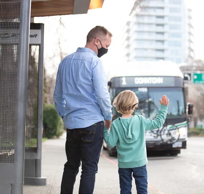 Man and child waiting at a bus stop