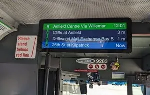 Digital information display inside a bus showing upcoming stops and arrival times