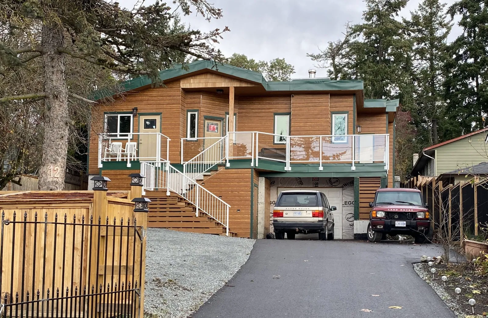 Photo of the two-storey single family dwelling at 12 Vickery Road showing the exterior, front stairs, and driveway with two parked vehicles.