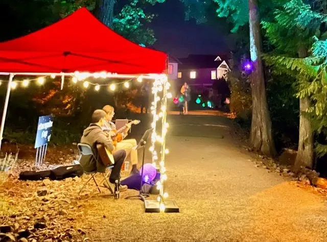 Musician performing under a red tent at West Shore Arts – Light Up the Hills