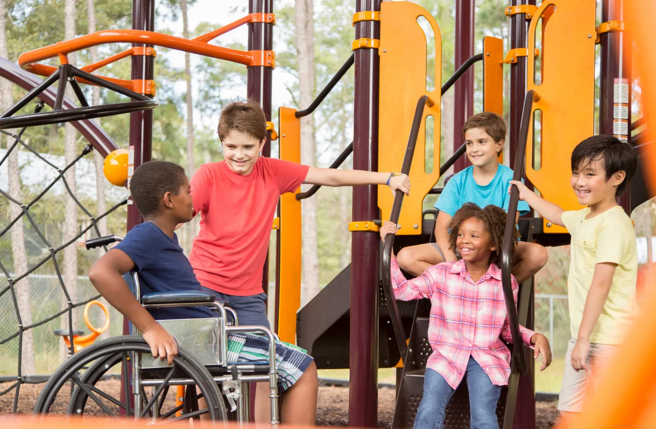 A diverse group of children playing together on a large playground climbing structure