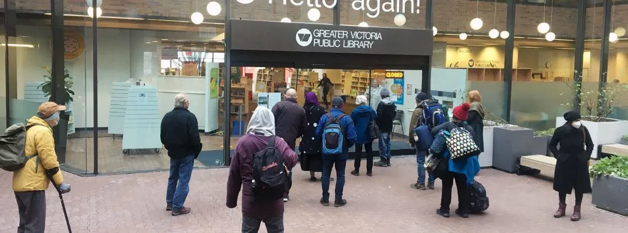 Exterior view of a library entrance with glass doors and a "LIBRARY" sign.
