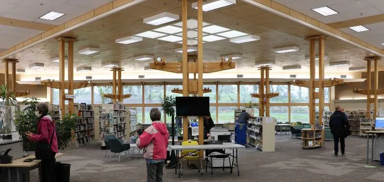 Two library staff members standing next to a colorful interactive display.