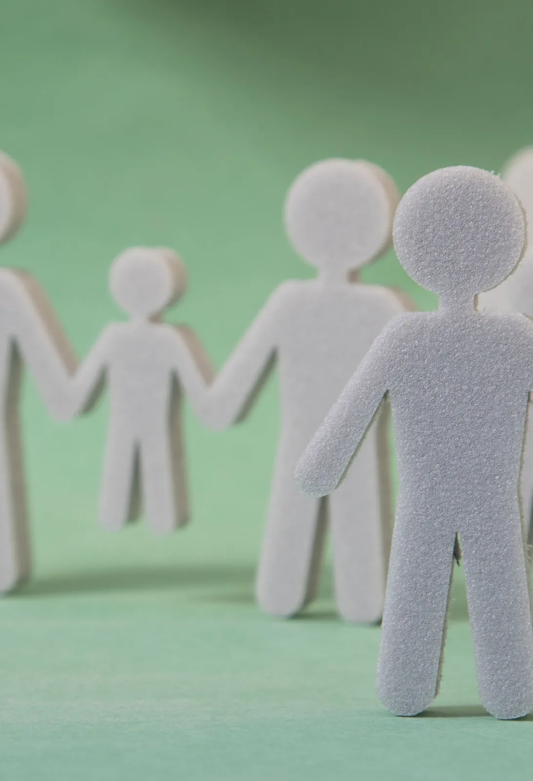 Paper cutouts of figures representing a family or community holding hands