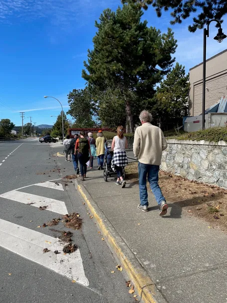 Group of people participating in a walkshop on a neighborhood sidewalk