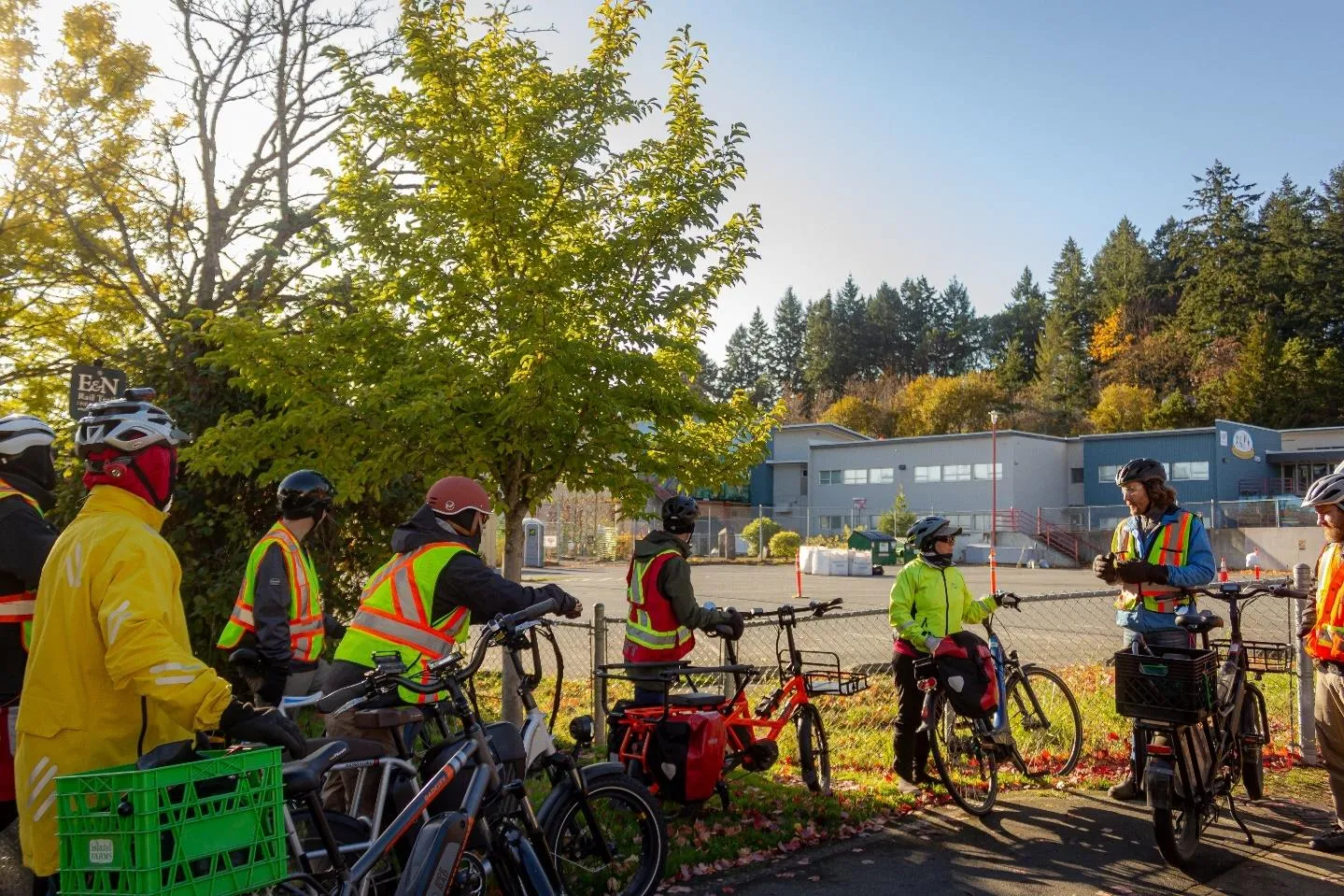 Group of people with bicycles and reflective vests gathered for a bikeshop tour