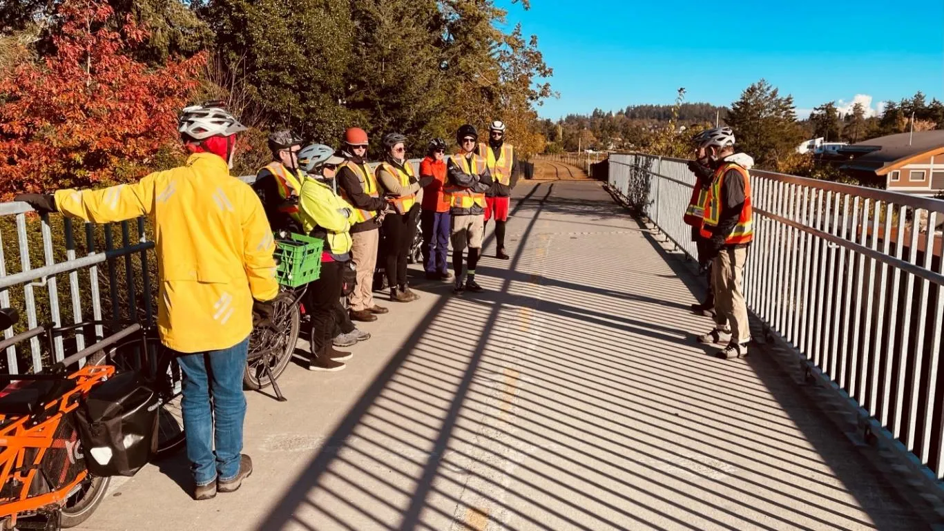 Photo of bikeshop participants on the Island Highway bridge discussing connectivity to the E&N Rail Trail