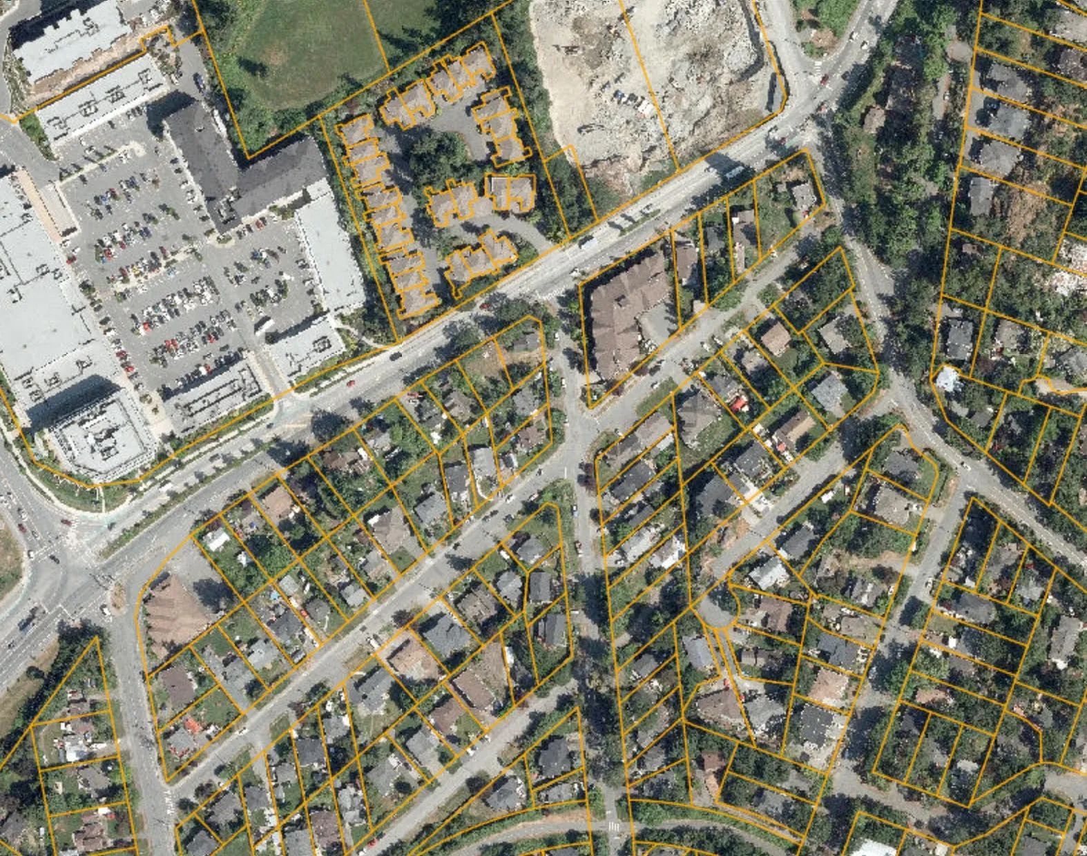 Wide aerial view of the neighborhood with the subject site outlined in yellow
