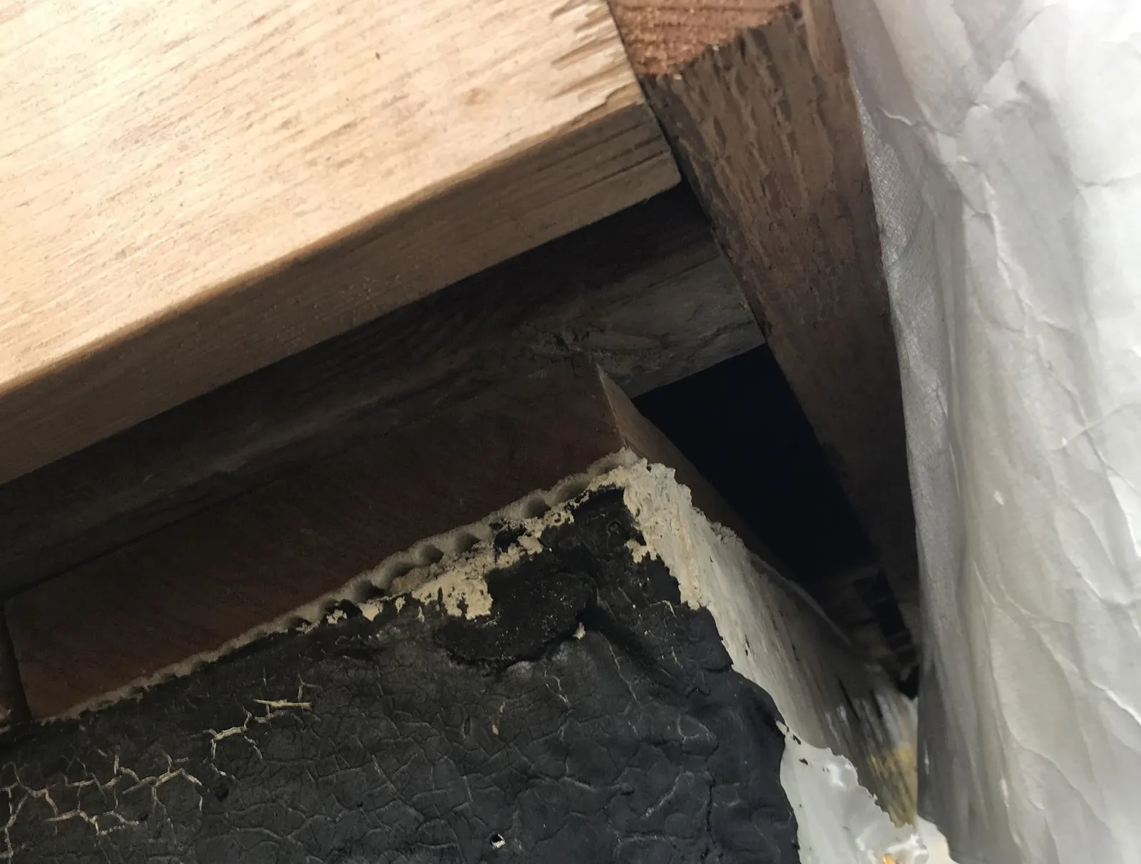Photo of wooden column supporting a beam with stamps visible on wood