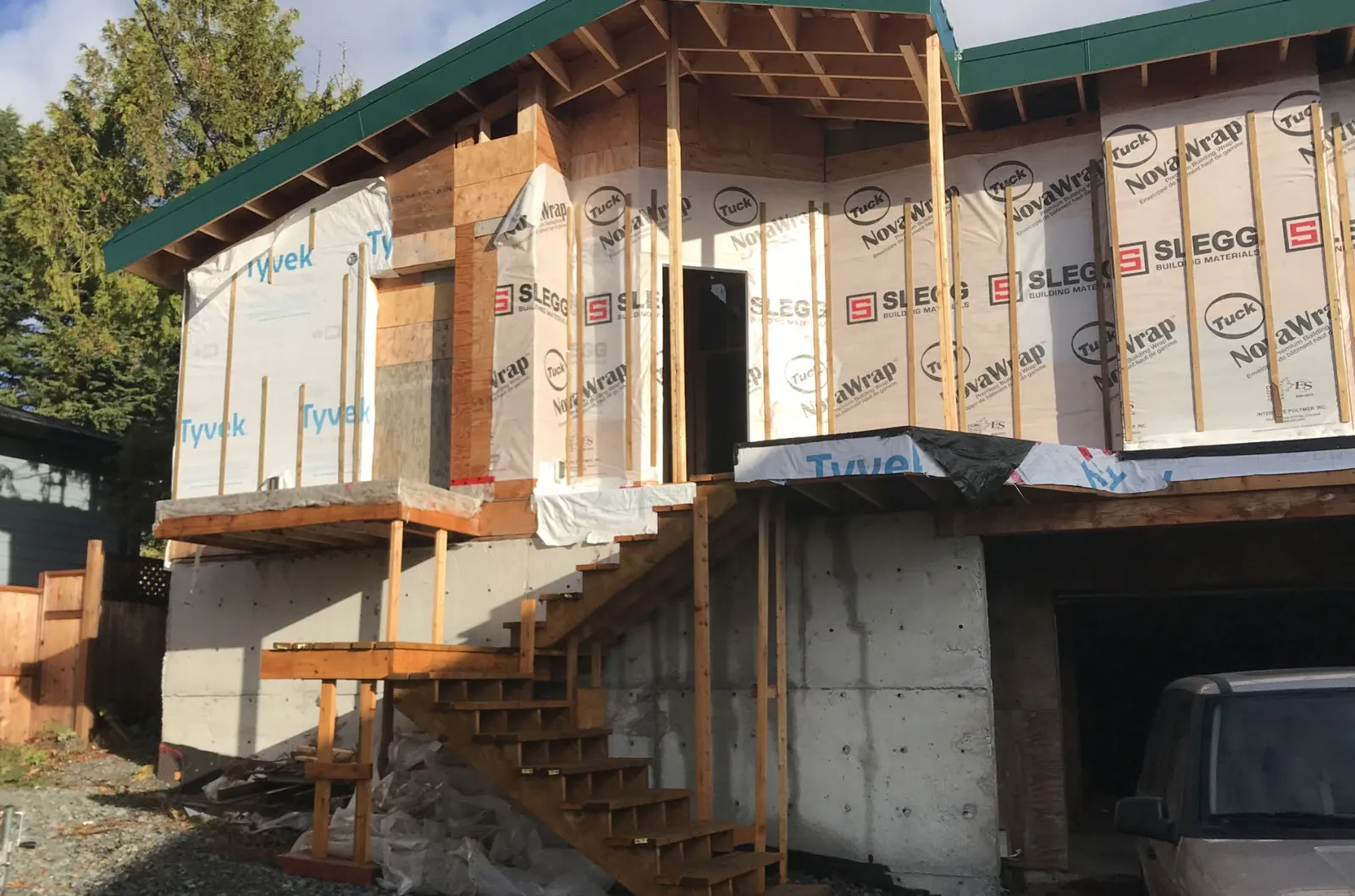 Photo of house exterior under construction showing sheathing and rainscreen on June 19, 2023