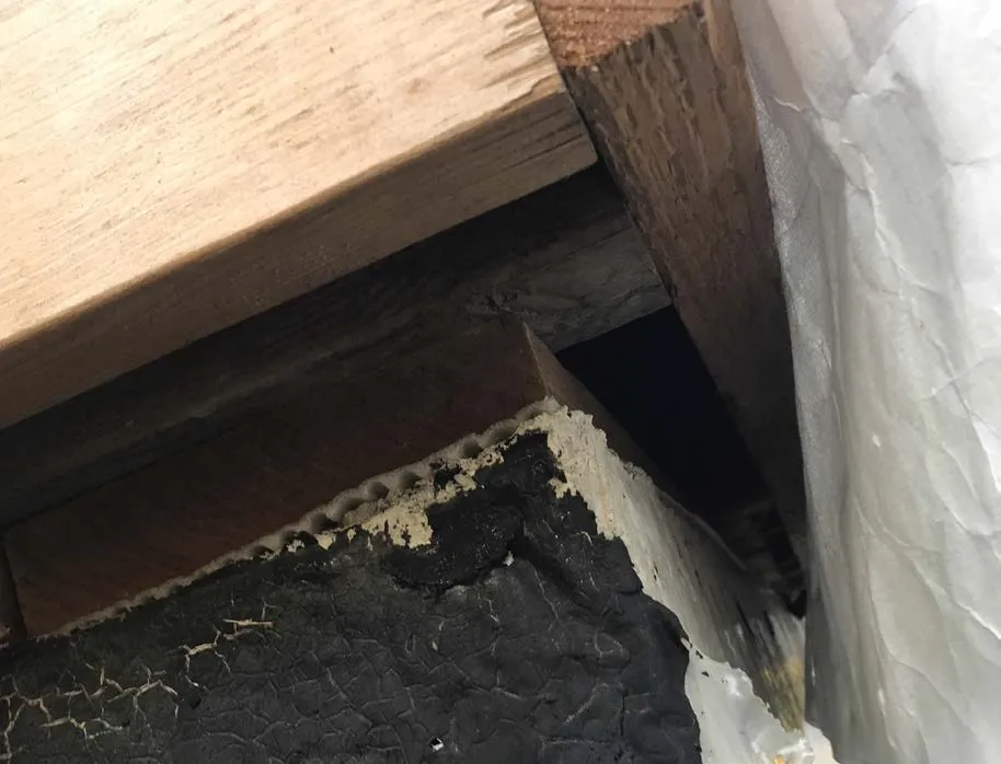 Underside view of wooden beams meeting a vertical support