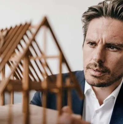 An architect or designer examining a wooden structural model