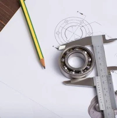 Drafting tools, blueprints, and a ball bearing