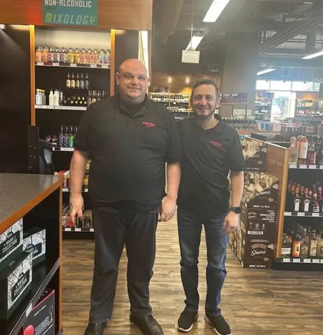 Two men standing together in a retail store setting