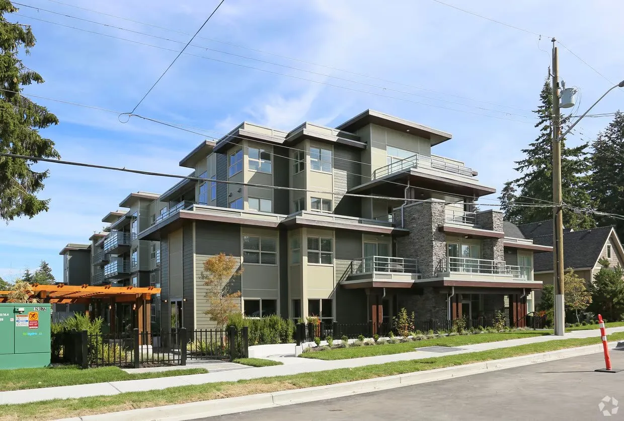 A modern multi-story apartment building with stone and wood accents