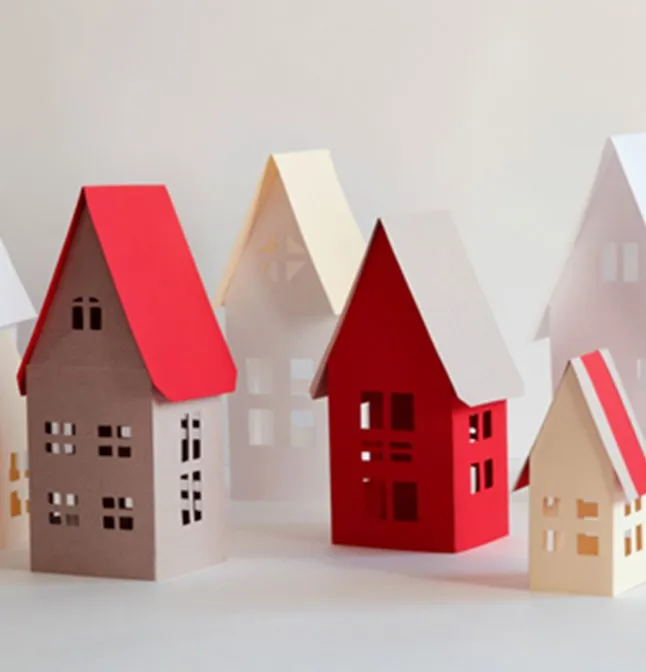 A group of colorful paper-cutout houses of various sizes and colors
