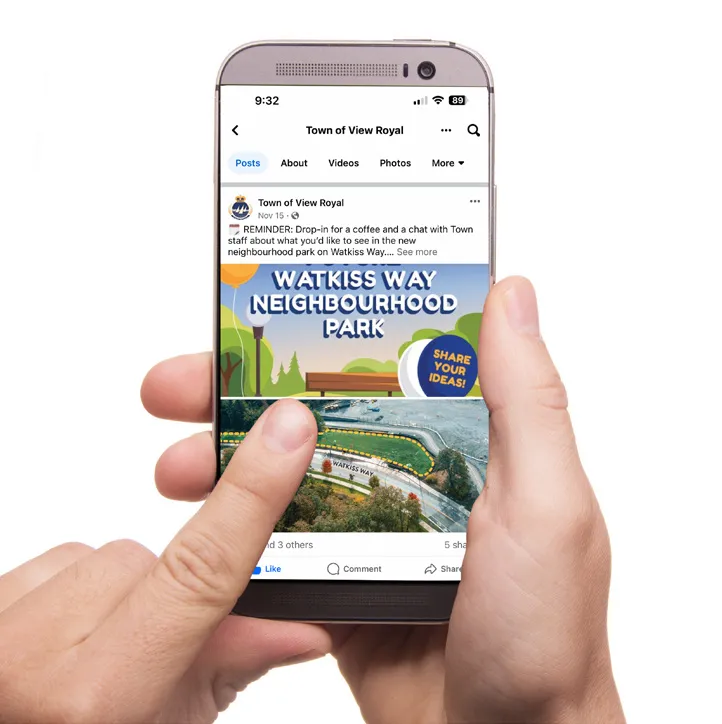 A person holding a smartphone showing a Facebook post from the Town of View Royal promoting the park engagement