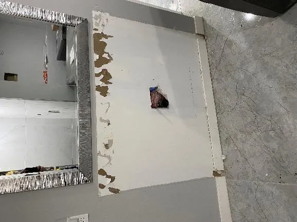 Capped plumbing on bathroom wall