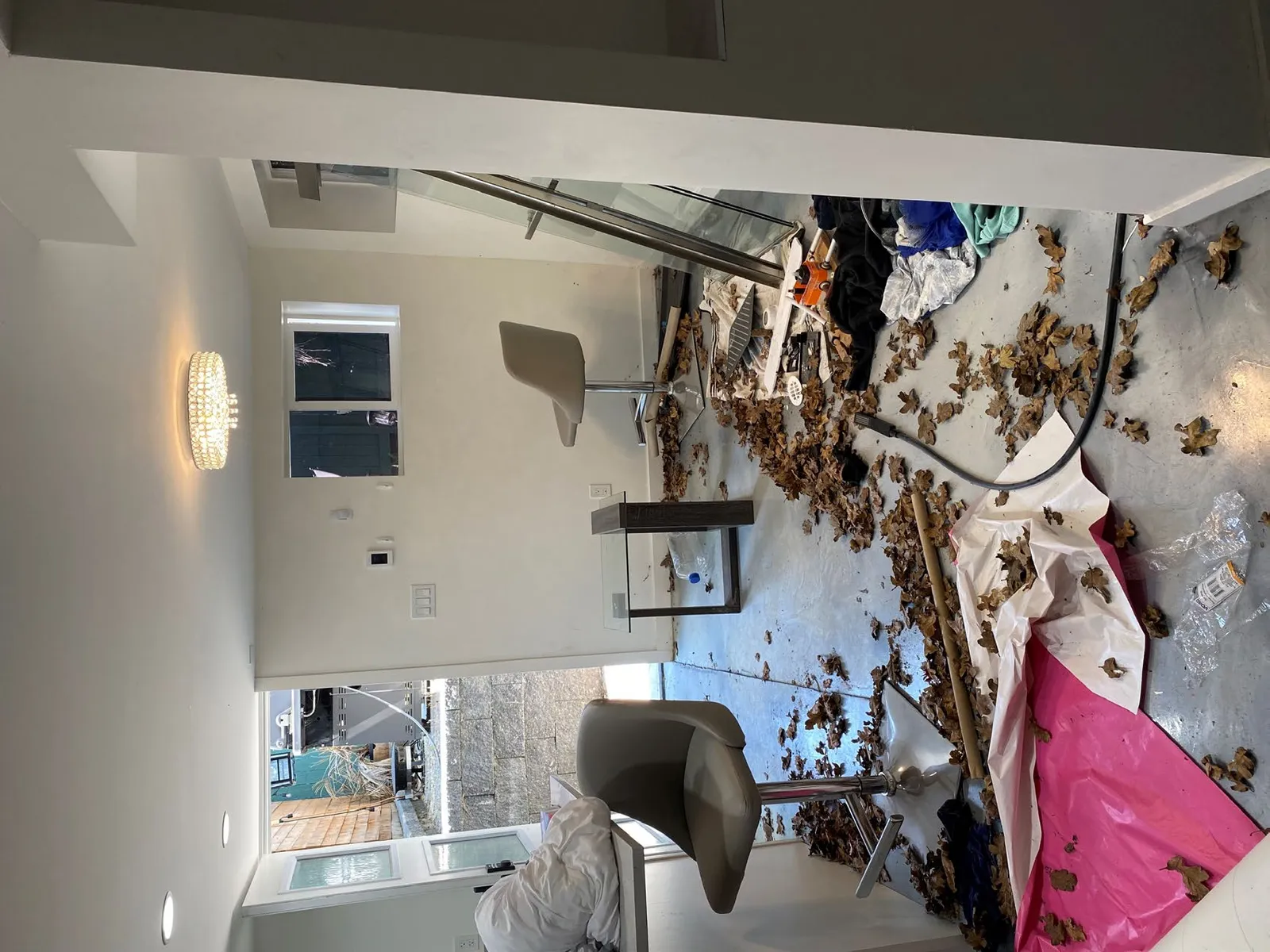 Interior view of a room filled with debris and leaves on the floor